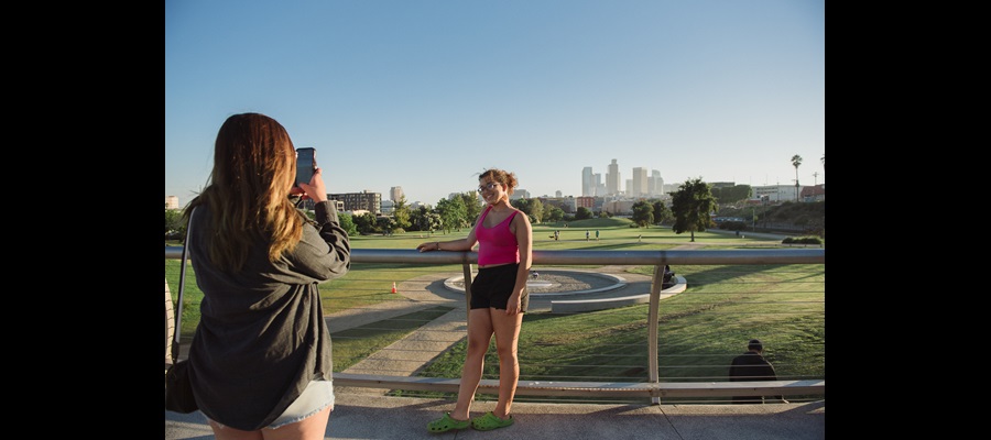 DiLA Student taking picture of another student with LA skyline behind them SU2023
